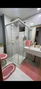 a bathroom with a glass shower and a sink at Apartamento 2 quartos com 1 suite in Serra