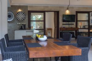 a dining room with a wooden table and chairs at Villa Cantik in Canggu