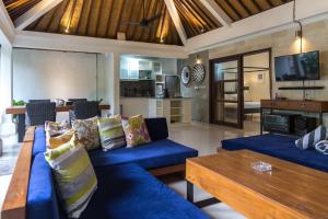 a living room with blue couches and a table at Villa Cantik in Canggu