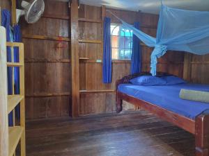 a bedroom with a bed with a mosquito net at Zest'house in Koh Rong Island