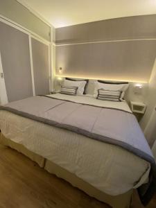 a bedroom with a large bed with white sheets and pillows at Ninety Suíte Premium in Sao Paulo