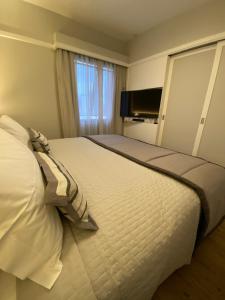 a bedroom with a large white bed with a window at Ninety Suíte Premium in Sao Paulo