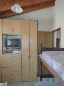 a bedroom with a bed and a tv and cabinets at Casa Obrien in Barraquero