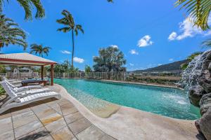 a swimming pool with a gazebo and palm trees at Spa Haven 17B Ocean View in Airlie Beach