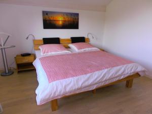 a bedroom with a large bed with two pink pillows at Ferienwohnung Hoherting in Prien am Chiemsee