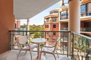 - Balcón con mesa y sillas en un edificio en Amora Hotel Riverwalk en Melbourne