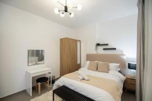 a white bedroom with a bed and a desk at Luxury Brand New 1BD Apt in AJMAN FREE Parking NEAR Beach in Ajman 