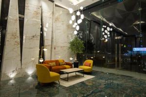 een lobby met een bank, 2 stoelen en een tafel bij Luxury Brand New 1BD Apt in AJMAN FREE Parking NEAR Beach in Ajman 