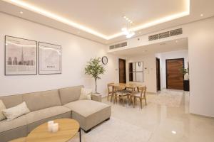 ein Wohnzimmer mit einem Sofa und einem Tisch in der Unterkunft Luxury Brand New 1BD Apt in AJMAN FREE Parking NEAR Beach in Ajman 