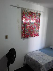 sypialnia z oknem z zasłoną i łóżkiem w obiekcie Santorini Flats w mieście Arraial do Cabo
