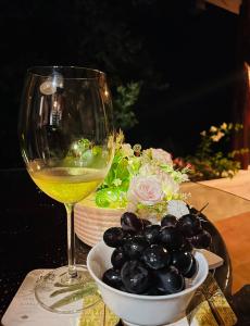 a glass of wine and a bowl of grapes at Villa La Fortuna Altos del Maria in Filipina