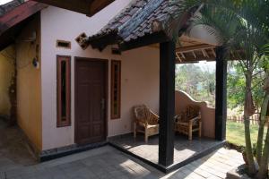 a house with a door and two chairs on a patio at Ramdan Homestay in Kuta Lombok