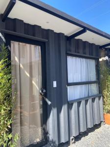 a black house with two windows and a door at hosteline in Villa de Leyva