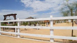 a white fence in front of a playground at Grape Valley Old West Cabins in Valle de Guadalupe