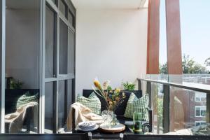 a balcony with a table and chairs on a patio at Modern Elegance Caulfield North in Melbourne