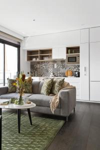 een woonkamer met een bank en een tafel bij Modern Elegance Caulfield North in Melbourne