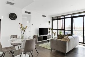 een woonkamer met een bank en een tafel bij Modern Elegance Caulfield North in Melbourne