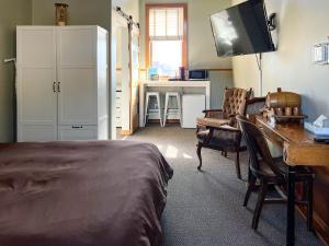 um quarto com uma cama, uma secretária e uma televisão em Endion Inn em Duluth