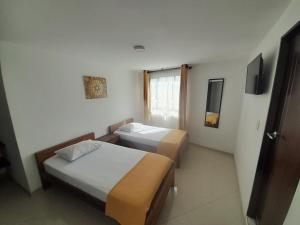 Cette chambre comprend 2 lits et une fenêtre. dans l'établissement HOTEL LA RUEDA SR, à Barbosa