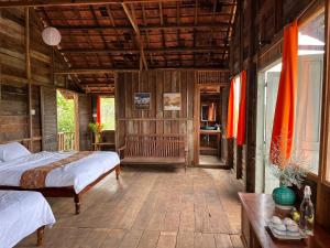 una camera con due letti in una stanza con pareti in legno di Boong House a Bảo Lộc