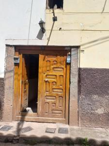 a large wooden door in the side of a building at Ataraxia Light House in Cusco