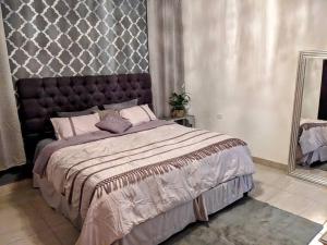 - une chambre avec un grand lit et un miroir dans l'établissement Casa Sol Descanso y Diversion, à San José del Cabo