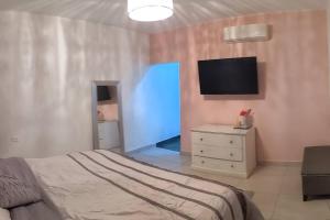 um quarto com uma cama e uma televisão na parede em Casa Sol Descanso y Diversion em San José del Cabo