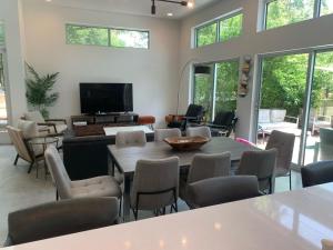 uma sala de estar com mesa e cadeiras em Stunning Modern Home w Pool & Hot Tub in DT Austin em Austin