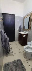 baño con aseo, lavabo y puerta negra en Casa Sol Descanso y Diversion en San José del Cabo