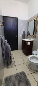 La salle de bains est pourvue de toilettes, d'un lavabo et d'une porte noire. dans l'établissement Casa Sol Descanso y Diversion, à San José del Cabo