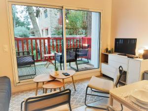 a living room with a large window and a television at Appartement moderne 3* avec balcon, proche du lac et plage, parking privatif, Wi-Fi inclus - FR-1-239-862 in Soorts-Hossegor