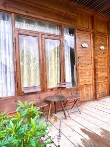 a porch with two chairs and a table and a window at Lâm Bích Homestay & Coffee in Ấp Phước Thánh