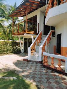 uma casa com uma escada que leva a uma varanda em Apartamento frente al mar entre Tolu y Coveñas em Puerto Viejo