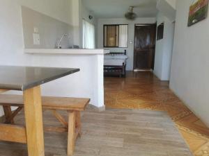 uma cozinha com uma mesa e um banco num quarto em Apartamento frente al mar entre Tolu y Coveñas em Puerto Viejo
