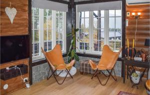 a living room with two chairs and a tv at Cozy Home In Fyresdal With House A Mountain View in Fyresdal