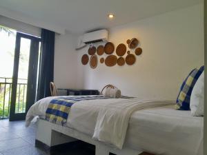 um quarto com uma cama grande e uma janela em Taman Unique Hotel em Senggigi