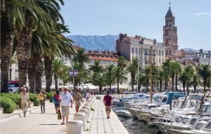 eine Gruppe von Menschen, die auf einem Bürgersteig in der Nähe von Booten spazieren in der Unterkunft Beautiful Apartment In Split With Wi-fi in Split