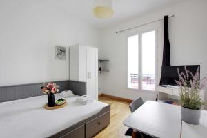 um quarto branco com uma secretária e uma janela em Charming and Cosy studio Levallois em Levallois-Perret