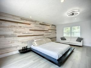 a bedroom with a wooden accent wall and a bed at Trout River Oasis in Jacksonville