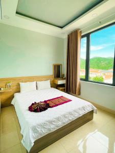 a bedroom with a large bed with a large window at Chau Gia Hotel in Vĩnh Hy