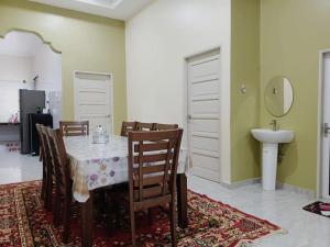 a dining room with a table and chairs and a sink at SERI IBAI DAMAI in Kuala Terengganu