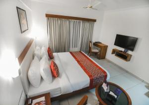 Habitación de hotel con cama y TV en KKM INTERNATIONAL en Thiruvananthapuram