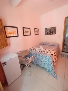 a bedroom with a bed and a table and a small table at Pousada Luzena in Morro de São Paulo