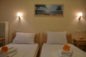 パラリア・カテリニスにあるGrand Blue Hotelの花が2本飾られた部屋のベッド2台