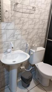 Baño blanco con aseo y lavamanos en Hotel Turazzi en Cáceres