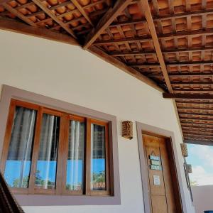 Habitación con ventanas y techo de madera. en Maravilha em Tibau do Sul en Tibau do Sul