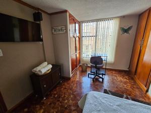 a bedroom with a bed and a desk and a chair at Aparta estudio de la panamericana in Pasto