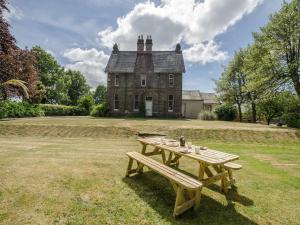 a wooden picnic table in front of a house at Albion House in Castle Douglas
