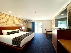 莫兰巴Western Heritage Motor Inn的一间配有床和书桌的酒店房间 更多29张照片