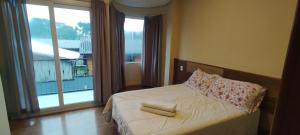1 dormitorio con 1 cama con 2 toallas en Casa Joaninha centro, en Canela